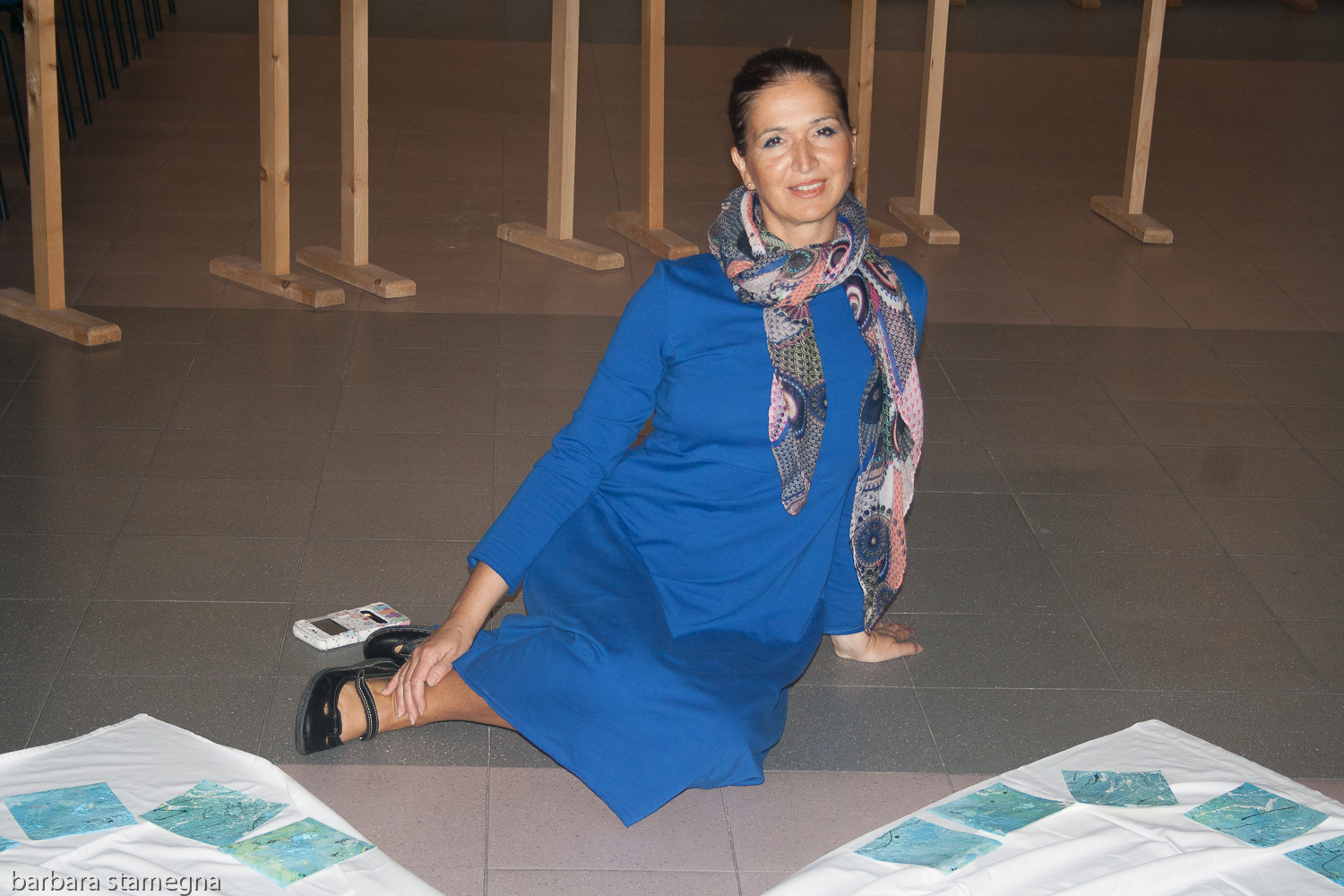 Barbara Stamegna sitting next to her Pieces Painting Project art installation during an exhibition